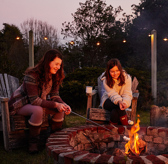 Young women roasting marshmallows