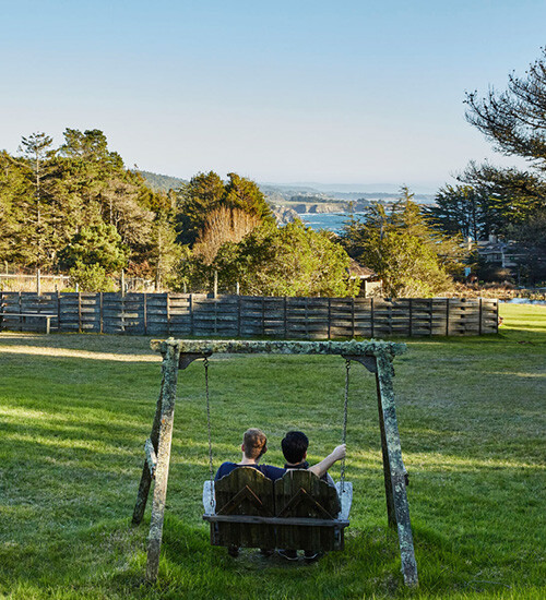 Two men sitting on an outdoor swing together