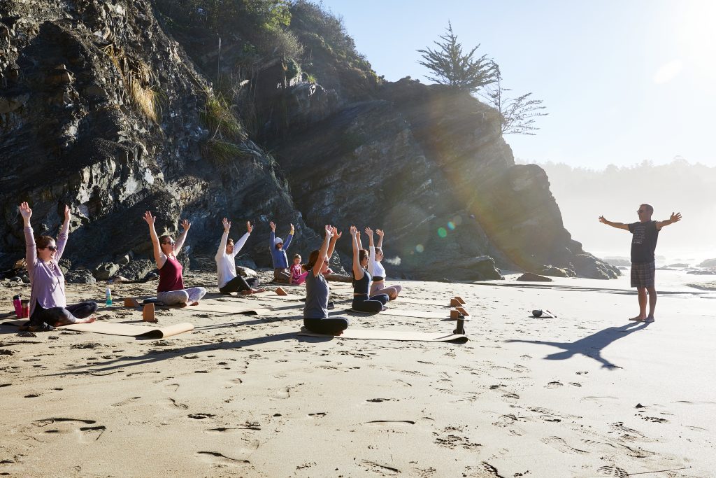 Image of yoga teacher with students on the beach