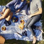 Two people enjoying a picnic on a picnic blanket