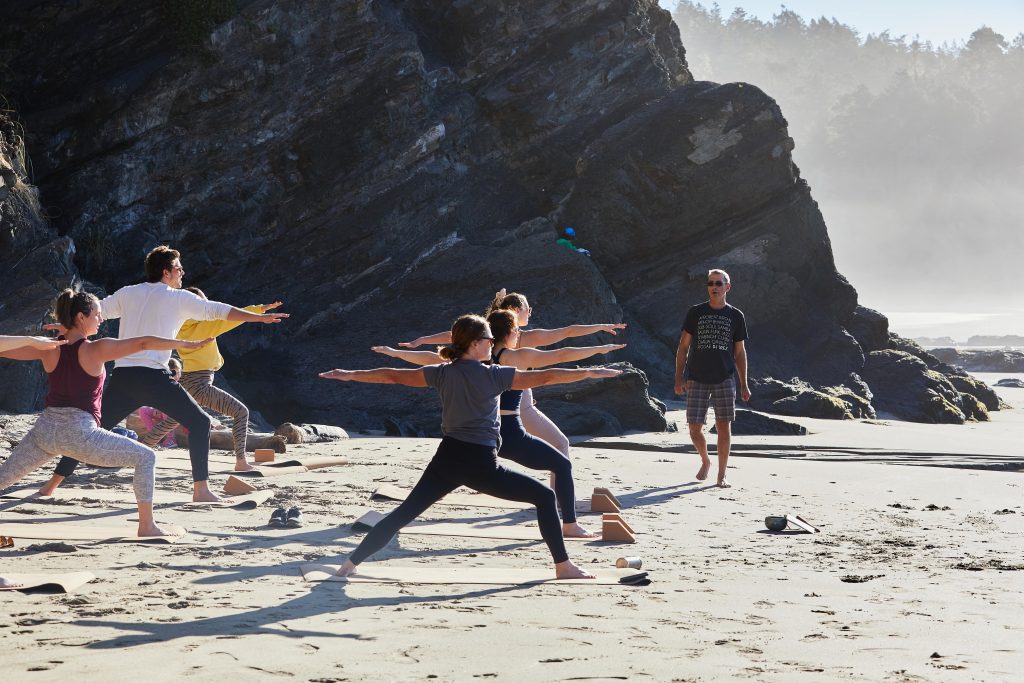 Guided beachside yoga during wellness retreat